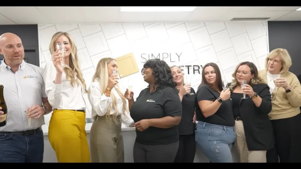 Group of diverse professional women chatting and laughing in an office.
