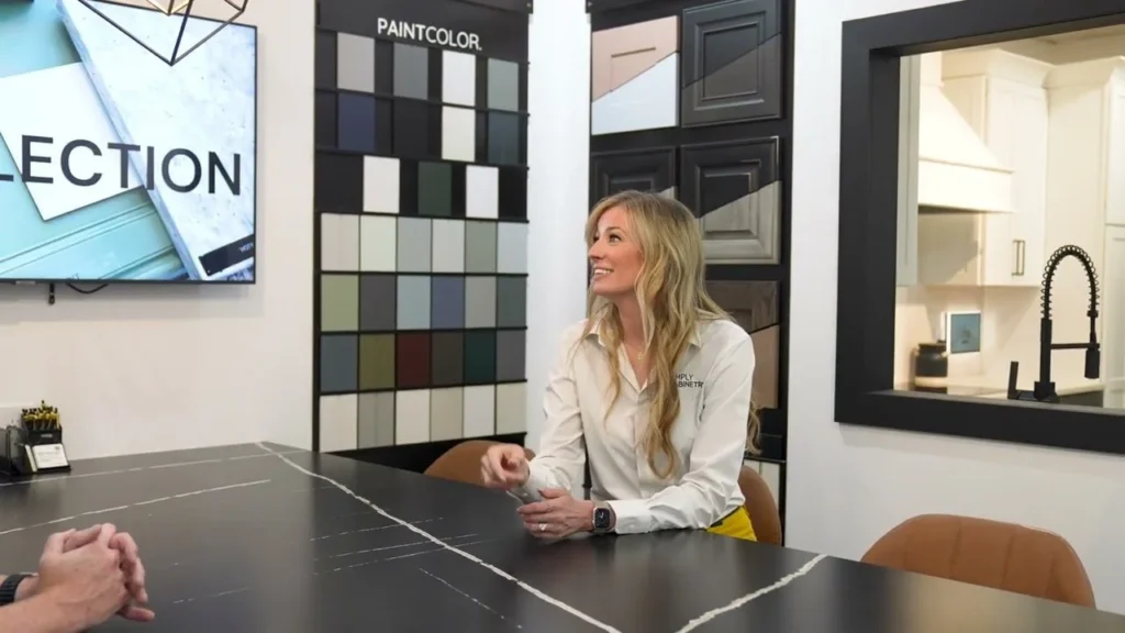 Woman reviewing color swatches and samples at a showroom table.