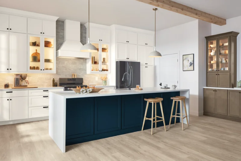 Modern white kitchen with a navy blue island.
