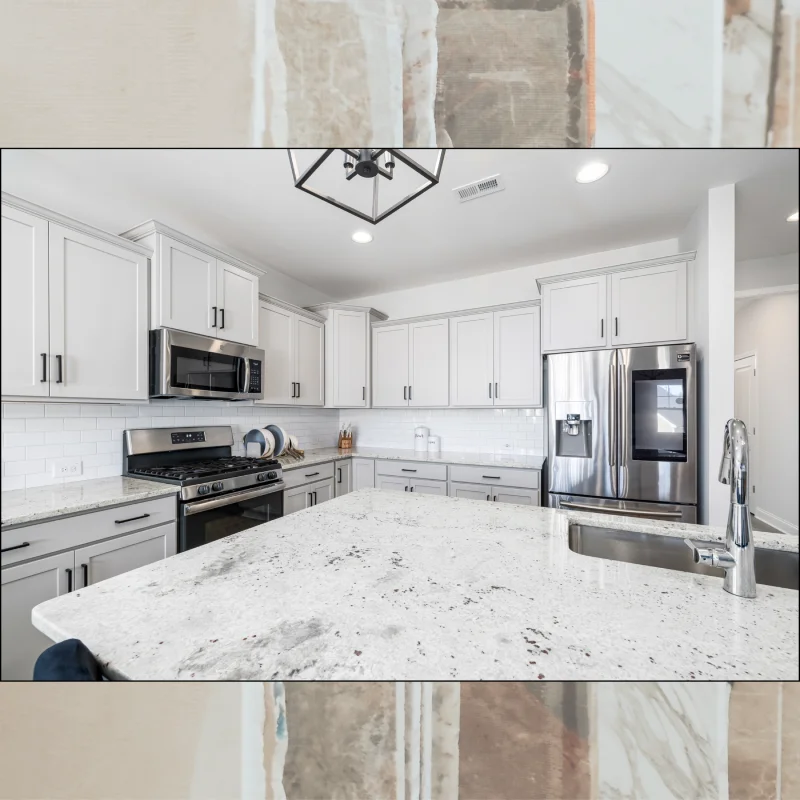 Bright kitchen featuring white shaker cabinets and a large granite island.