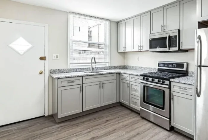 L-shaped kitchen featuring light gray cabinets, granite countertops, and stainless steel appliances.