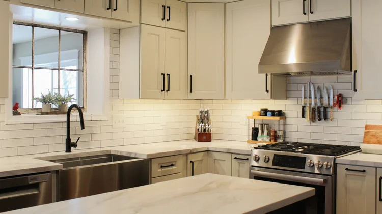 Classic off-white shaker cabinetry equipped with sleek modern stainless steel handles.