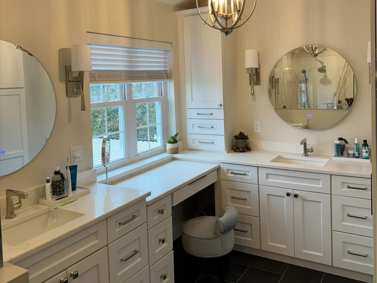 Custom white bathroom vanity suite with integrated makeup dressing table seating area.