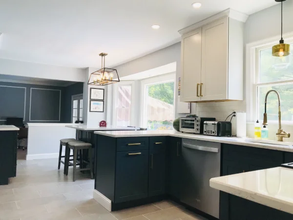 Modern kitchen featuring navy blue lower cabinets and white upper cupboards.