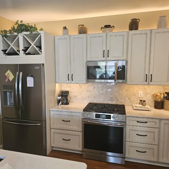 Bright kitchen layout featuring traditional white cabinets and stainless steel stove range.