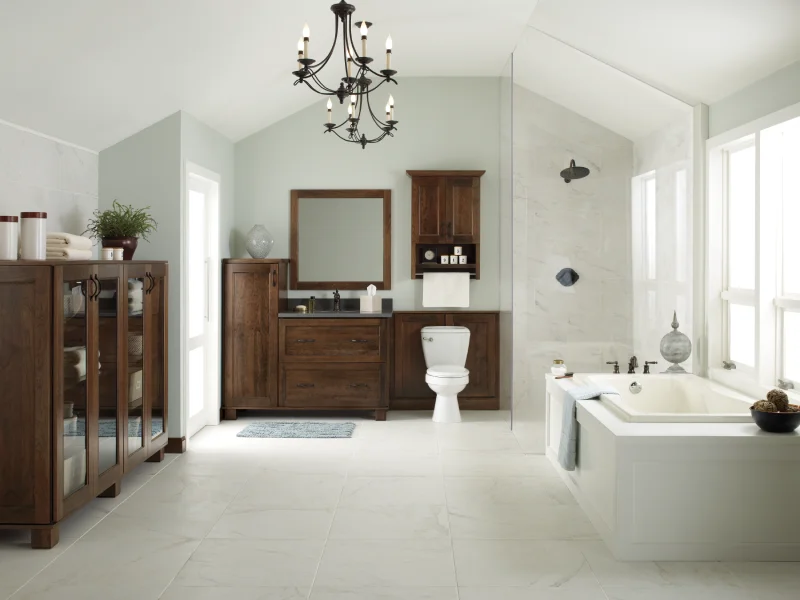 Spacious luxury bathroom with custom dark wood cabinets and a chandelier.