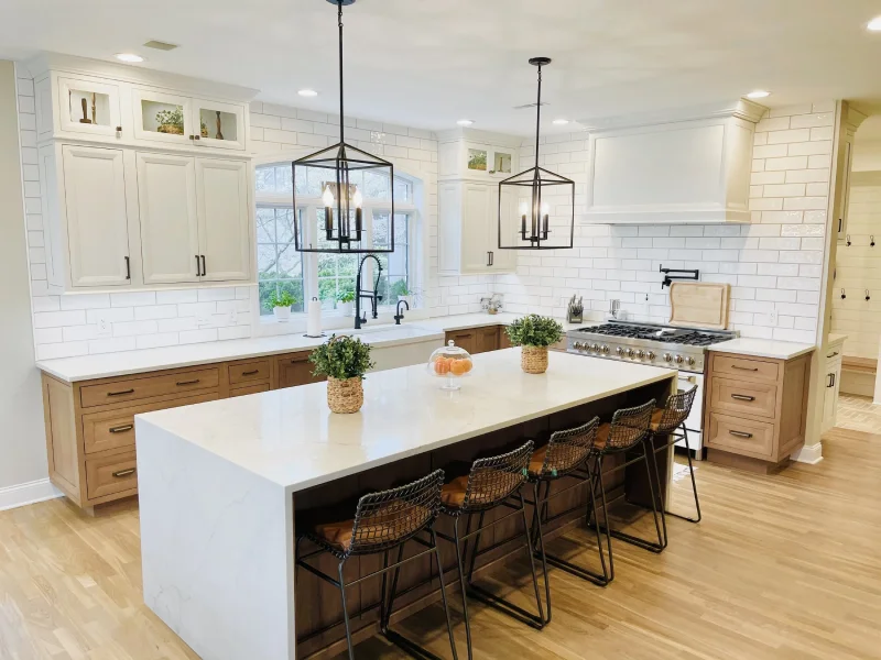 Modern farmhouse kitchen featuring wood base cabinets and a large white island.