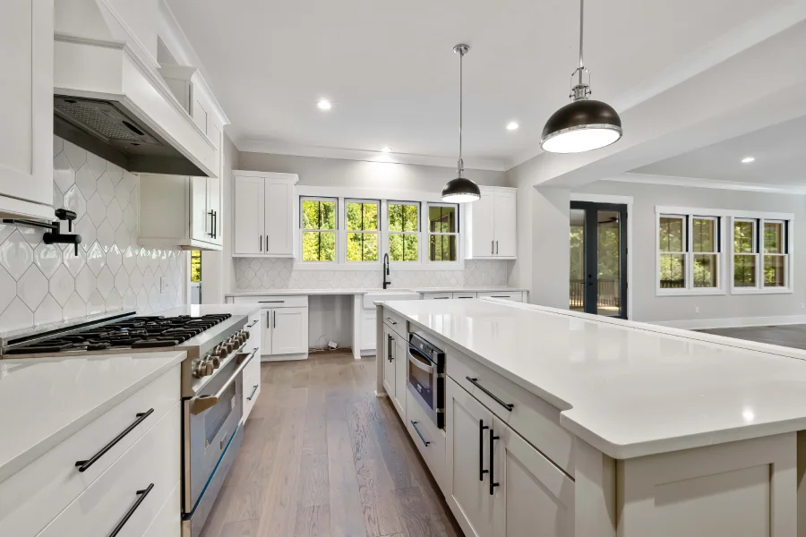 Bright custom kitchen layout with clean white perimeter cabinets and a long island.
