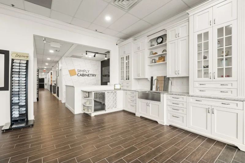 Custom white kitchen cabinetry featuring a patterned tile backsplash and gold fixtures.