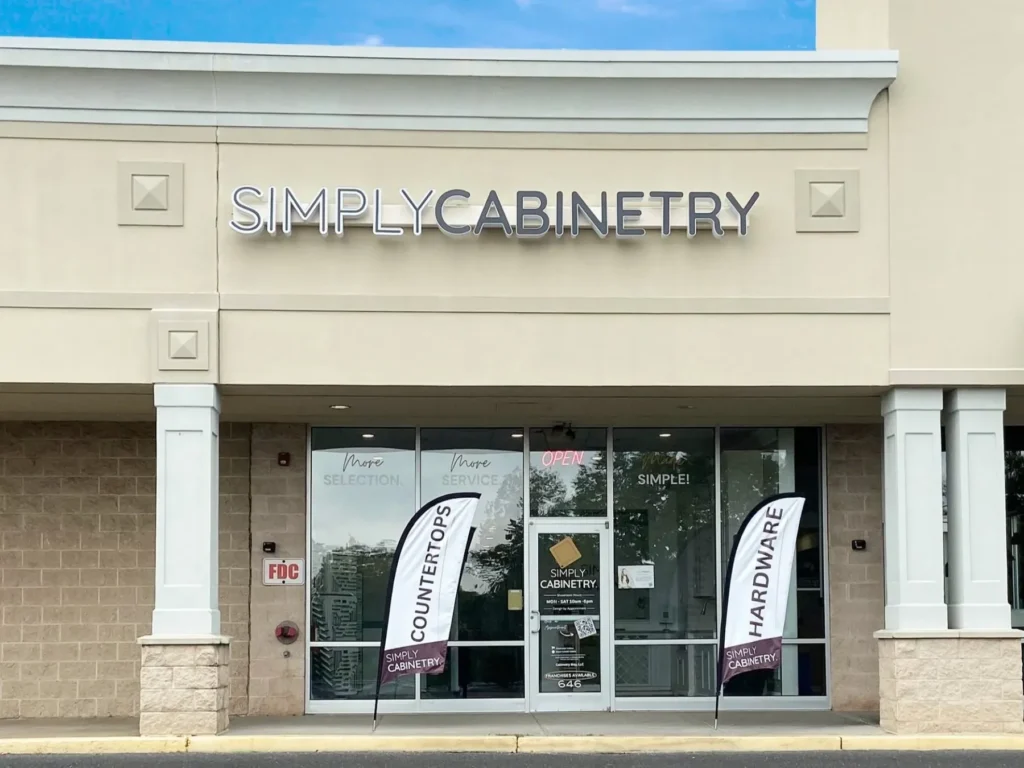 Front entrance of the Simply Cabinetry showroom building featuring clear glass storefront windows.