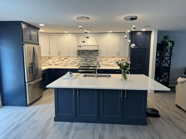 Modern blue kitchen island with a white countertop matching the light perimeter cabinets.