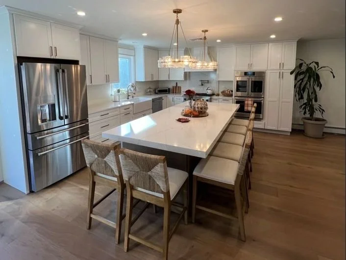 Open concept kitchen space featuring dual islands and bright multi-pendant light fixtures.