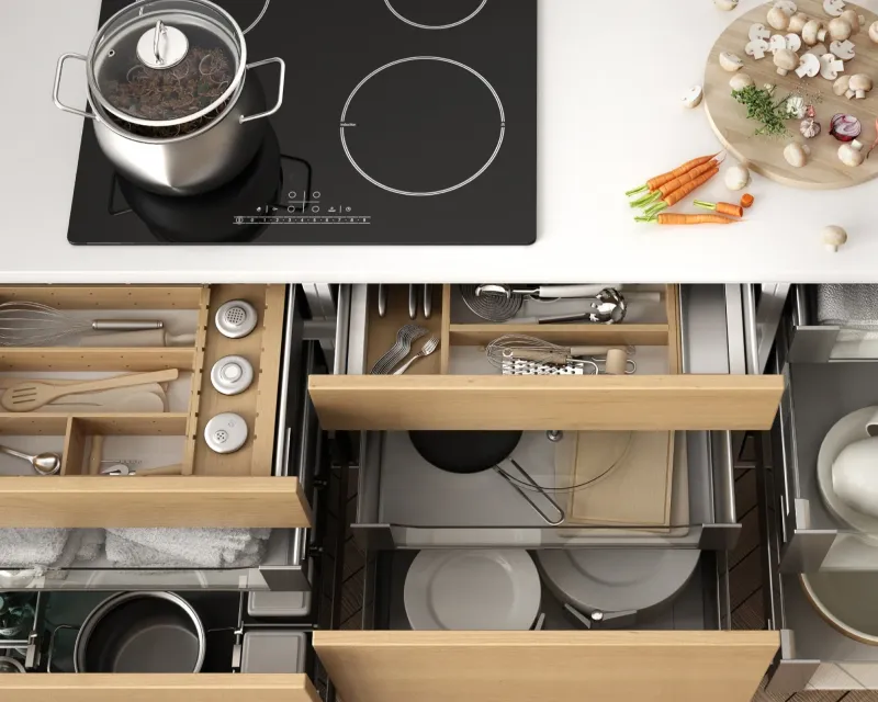 Top-down view of an electric cooktop and open wooden storage drawers.