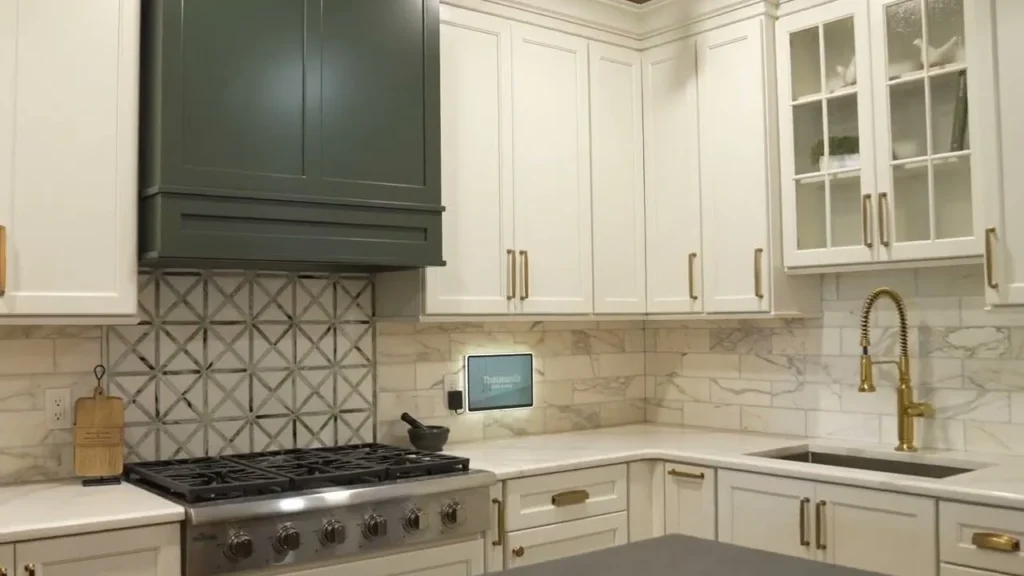 Custom white kitchen cabinetry featuring a patterned tile backsplash and gold fixtures.