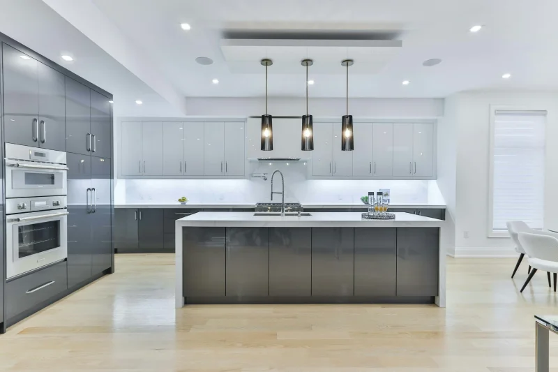 Modern open concept kitchen featuring seamless dark grey cabinets and a large island.